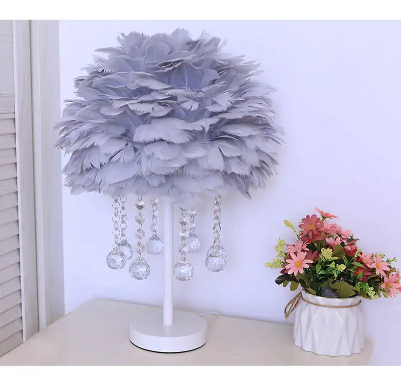 Feather lamp with hanging crystal droplets, decorative home lighting piece.